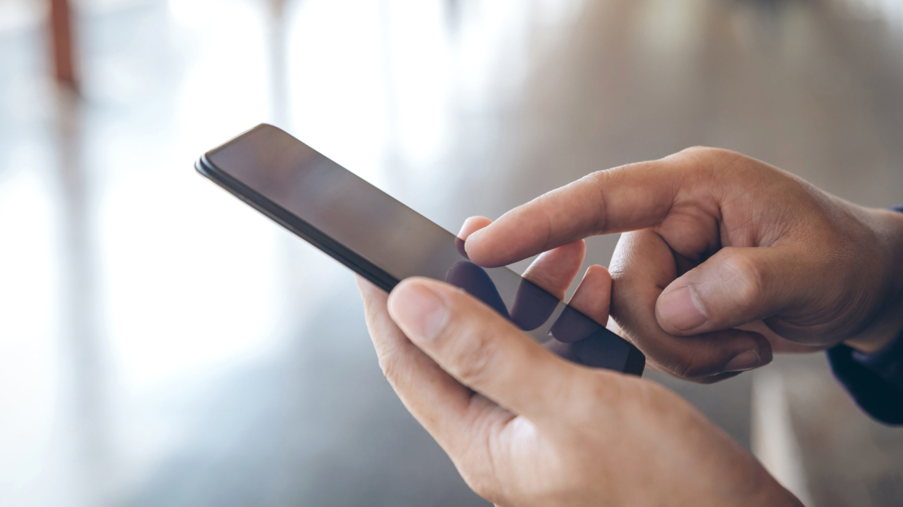 Close-up,Male,Hands,Using,Smartphone,On,City,Searching,Or,Social